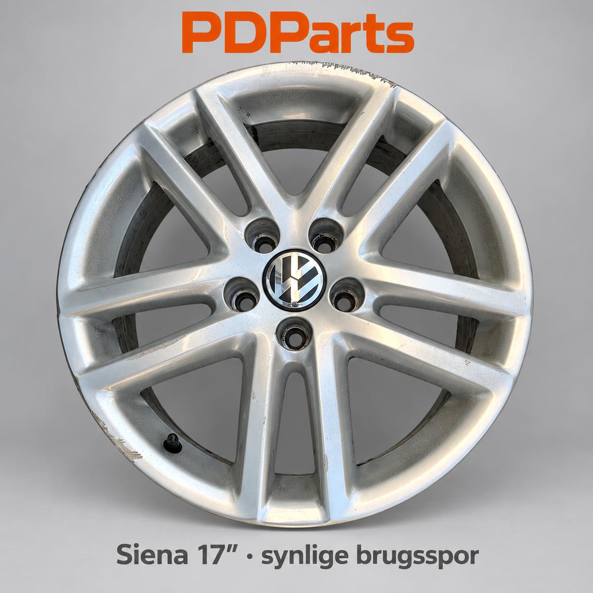 VW Siena 17″ – synlige kantstensmærker og lakafskalning på den konkrete fælg
